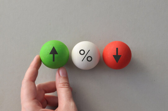 Interest rate comparison with increase decrease and percentage symbols on wooden balls