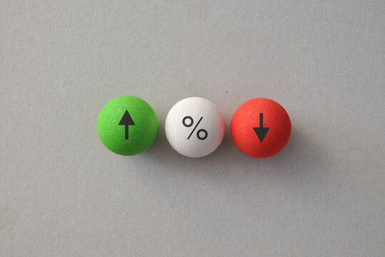 Interest rate comparison with increase decrease and percentage symbols on wooden balls