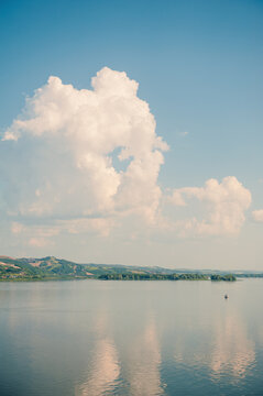 Scenic river reflects blue cloudy sky. Peaceful landscape
