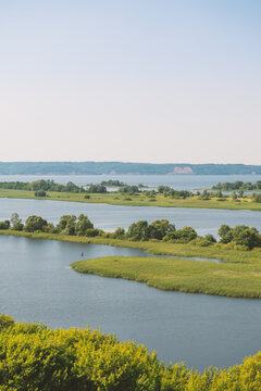 Natural scene with tranquil river meanders through green field and open marsh