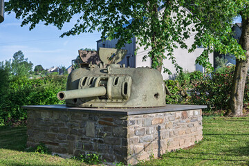 Historical World War II American tank turret monument on a stone pedestal by an information sign in the village of Marvie near Bastogne, Belgium. © Rudolf