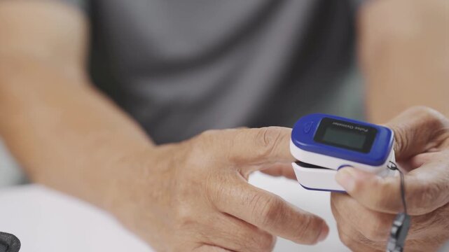 Close up of a senior opening a fingertip pulse oximeter before measuring blood oxygen saturation and pulse rate at home, representing home healthcare, selfcare, respiratory monitoring.