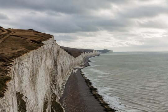 Dover white cliffs and expansive coastline, overcast weather, cinematic landscape.