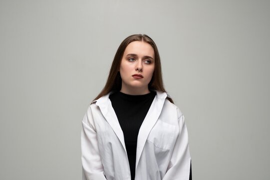 Young woman showing sad and indifferent expression, feeling bored and apathetic, looking away sideways