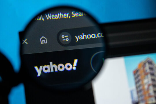 Magnifying glass over Yahoo search bar on a digital screen with blue background light