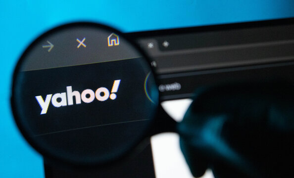 Magnifying glass over Yahoo! search engine on a dark browser interface with blue background