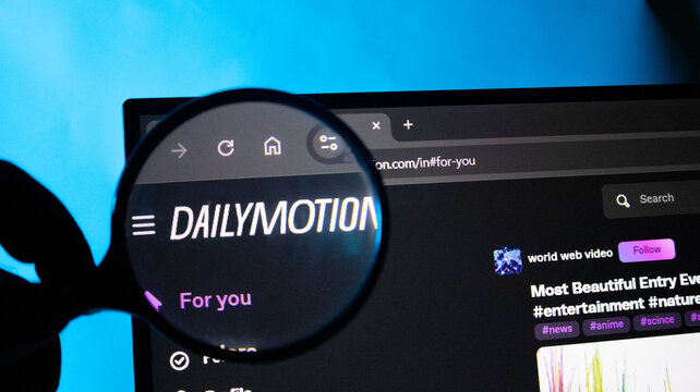 Magnifying glass over Dailymotion website on a laptop screen with blue background