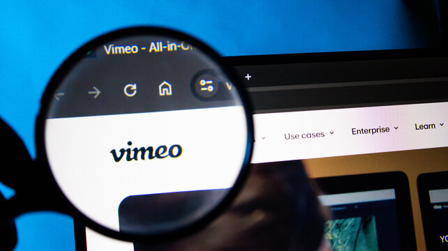 Magnifying glass over Vimeo website on a computer screen with blue background
