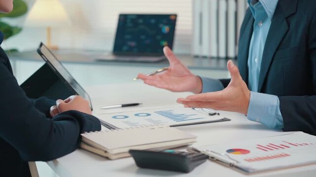 Business colleagues analyzing financial data and statistics during a corporate strategy meeting in the office