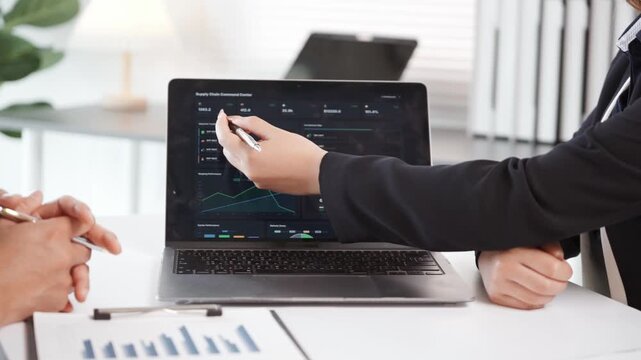 Business colleagues collaborating on a data analysis dashboard for supply chain management and business intelligence