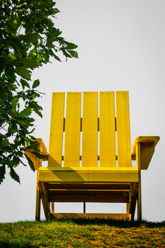 Giant yellow Adirondack Cape Cod chair at the Riverfront Park hilltop green overlooking Middlebury Falls in Middlebury, Addison County, Vermont, United States of America