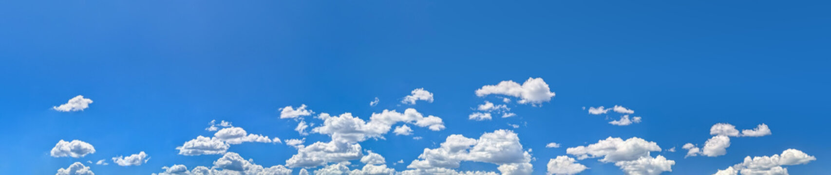 Rows soft steam stretch forming a striking natural pattern. Cloud layers moving dynamically right to left. Cumulus clouds clusters warm summer day vast blue sky. Large copy space above for writing.