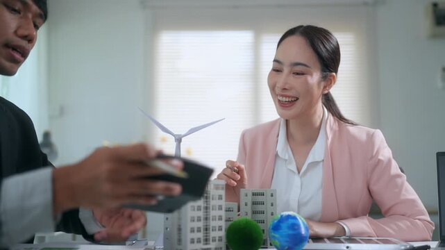 Real estate agent presenting sustainable eco friendly building project to a client during a business meeting in the office
