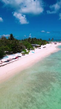 Aerial cloudscape over turquoise island, billowy white clouds above lush green shoreline, white sand beach and distant floating dome, expansive horizon and cinematic sky, Himmafushi island, Maldives