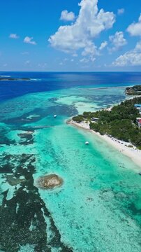 Aerial village harbor and sandy beach, small marina and palmfringed village, docks and moored boats in shallow turquoise water, local coastal activity and resort amenities, Himmafushi, Maldives