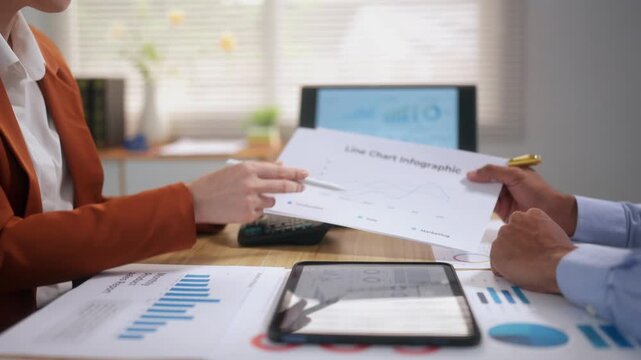 Business colleagues reviewing financial data and infographics during a corporate team meeting in the office