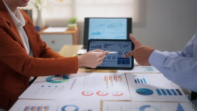 Business colleagues analyzing financial data charts and graphs during a corporate meeting in the office boardroom