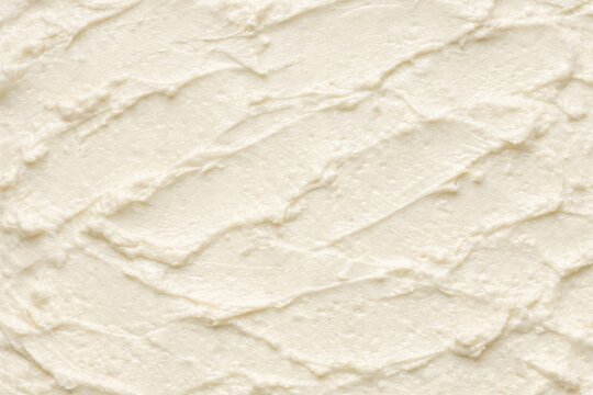 Smooth white creamy texture with soft ridges and swirls. Food background. Dairy or frosting surface concept, culinary design, bakery, and product presentation visuals.