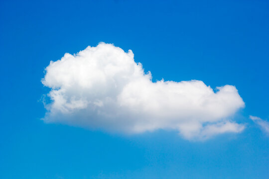 Single Fluffy White Cloud on Vivid Blue Sky Background