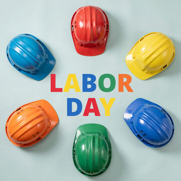 Labor day usa canada celebration colorful hard hats arranged around holiday text on light blue background