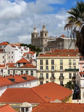 View of the historic Alfama district in Lisbon featuring traditional terracotta rooftops and the twin towers of Mosteiro de S&atilde;o Vicente de Fora (Monastery of S&atilde;o Vicente de Fora) rising above the hill