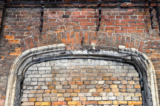 bricked-up arch gate in wall of abandoned factory