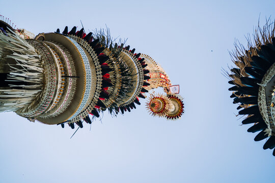 Intricate Balinese Penjor poles decorated for Galungan festival along a street in Bali, Indonesia
