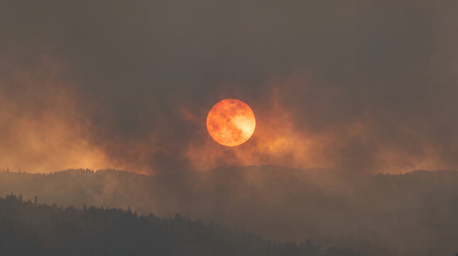 Sunset over smoky mountains creating dramatic orange sky  
