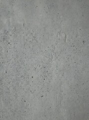 Fototapeta premium Minimalist gray concrete wall surface featuring natural pitted texture and industrial aesthetic for modern architectural backgrounds