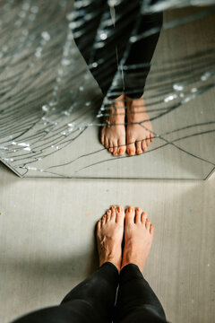reflection of feet in a broken mirror 