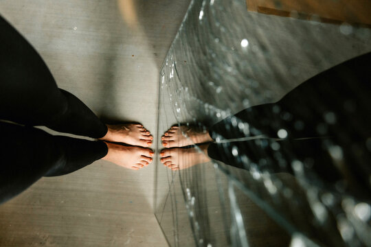 reflection of feet in a shattered mirror 