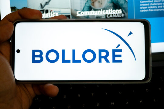 Person holding mobile device displaying bollore logo