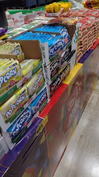 ITABIRA, MINAS GERAIS, BRAZIL - JULY, 2026: Traditional Festa Junina product display at a wholesale supermarket, featuring stacks of popcorn packages, corn kernels, peanuts, and winter festival ingred