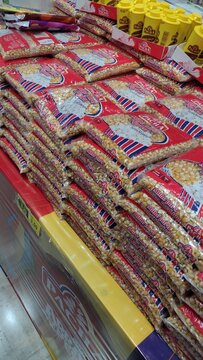 ITABIRA, MINAS GERAIS, BRAZIL - JULY, 2026: Traditional Festa Junina product display at a wholesale supermarket, featuring stacks of popcorn packages, corn kernels, peanuts, and winter festival ingred