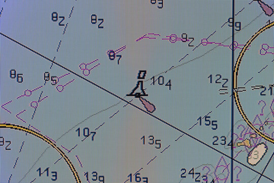 Digital nautical chart display with navigation symbols, depth soundings, compass lines and route plotting. Marine map conveys maritime navigation, chart reading. Macro photo of a buoy sign