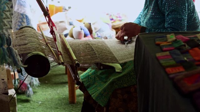 Vietnamese woman weaving traditional fabric on a wooden loom
