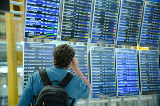 Man looking at airport departure arrival board
