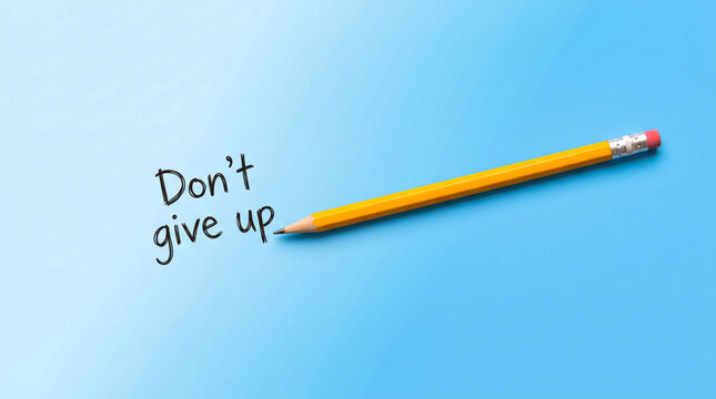 Yellow pencil writing don&rsquo;t give up motivational message on blue background