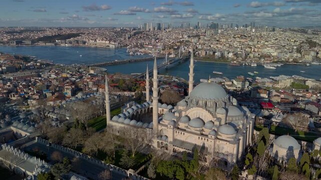 Aerial drone view of the historic Golden Horn in Istanbul, showing the Suleymaniye Mosque, Galata Bridge and the Bosphorus. Galata Tower and Taksim Square in the distance.