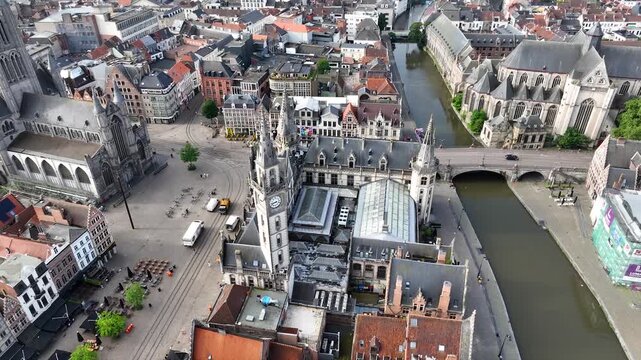 Aerial drone view of Ghent old town in Belgium, with the towers of St. Nicholas and St. Michael's Churches and Castle of the Counts next to river Lys. Architecture and landmarks of the medieval city.