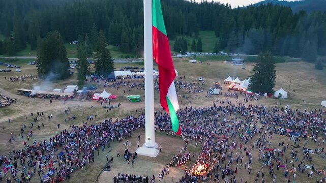 Drone View of Raising the largest and tallest Bulgarian flag on the highest pole on Rozhen Peak in the Rhodope Mountains, near Pamporovo resort, Bulgaria.