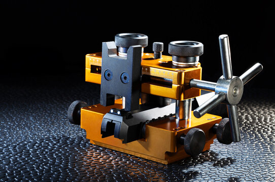 Orange vise adjusting the rear sights on a pistol slide