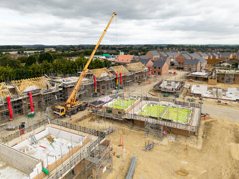 Aerial view above a new build housing construction site in the UK with homes under construction
