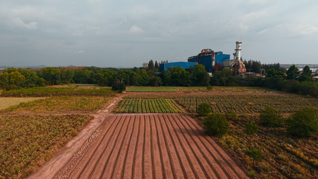 Industrial facility standing behind diverse agricultural fields