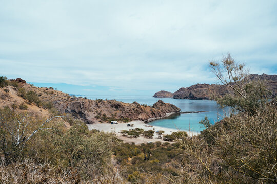 camping truck parked in two turquoise coves between rocky desert