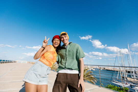 Cheerful young couple enjoying summer vacation at harbor