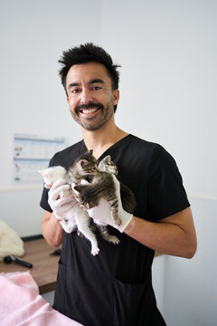 Veterinarian holding kittens smiling at animal clinic