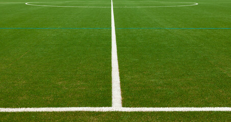 Fototapeta premium Green soccer field with withe center mark. Sports field for training and competitions. Leisure activity, sports facility, soccer field, recreational activities, sports club.