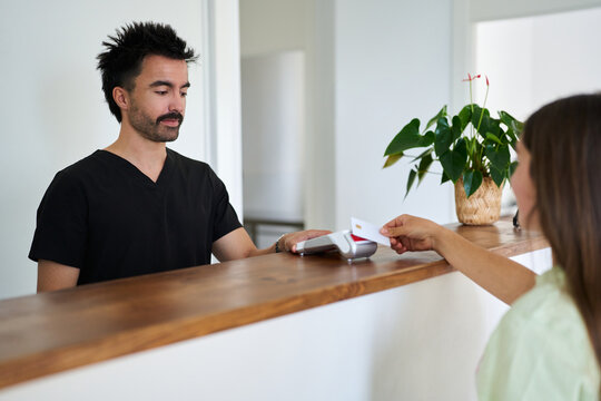 Veterinarian assistant assisting customer making contactless