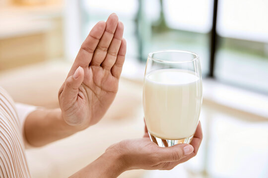 牛乳を拒否する手：乳糖不耐症や牛乳アレルギーのイメージ